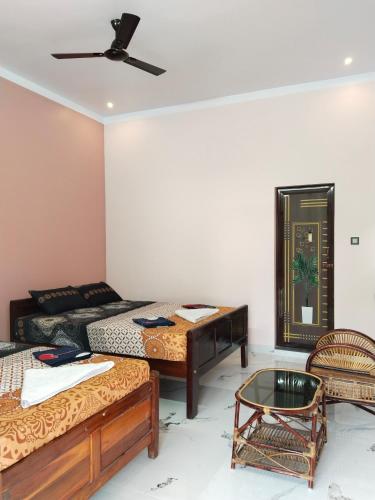a living room with two beds and a couch at Mayurah Illam in Kanyakumari
