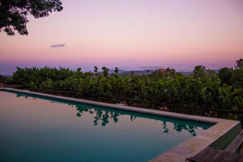 una piscina con puesta de sol en el fondo en Clave Verde Ecolodge, en Las Terrenas