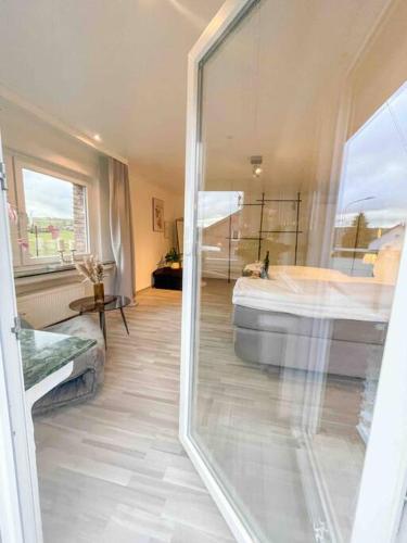 a bathroom with a tub and a large glass window at Charmantes LandRefugium Eifel in Kall