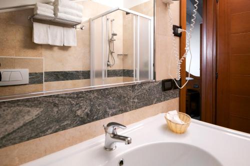 a bathroom with a sink and a mirror at Hotel Ungheria Varese 1946 in Varese
