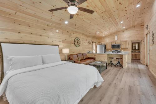 a bedroom with a white bed and a kitchen at Follies Cottage, Pickleball Court, Creek, WIFI, Mountain Views, Starting at 79" in Cosby