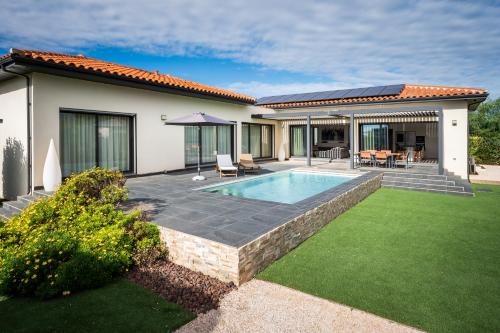 une cour arrière avec une piscine et une maison dans l'établissement Villa Alicia, à Claira