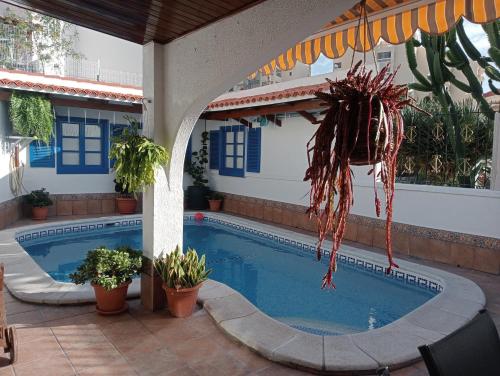 een zwembad met een parasol naast een huis bij Beautiful Holiday Villa with heated private pool, Los Cristianos in Los Cristianos
