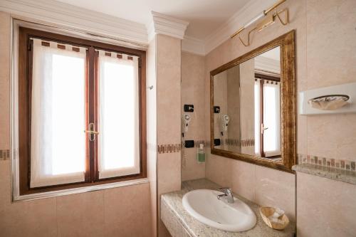 a bathroom with a sink and a mirror at Hotel Ungheria Varese 1946 in Varese
