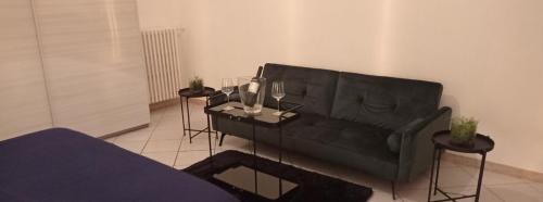 a living room with a black couch and two tables with glasses at RUDIAE Palace In Lecce in Lecce