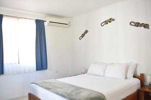 a bedroom with a bed and a window at Fuego Lodge in Santa Teresa Beach
