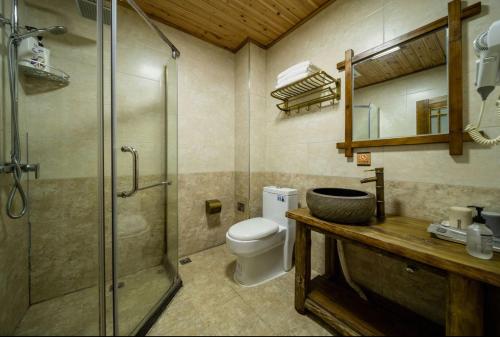 a bathroom with a shower and a toilet and a sink at Mountains Beyond Mountains Inn in Zhangjiajie