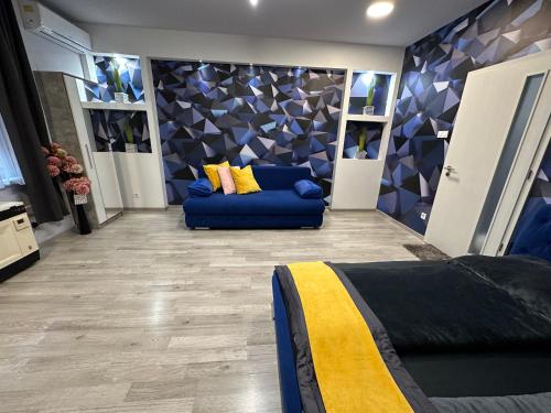 a living room with a blue couch in a room at Kitty Downtown Apartman in Debrecen
