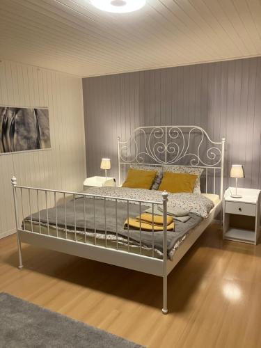 um quarto com uma cama de metal com almofadas amarelas em La Lanterne em Sierre