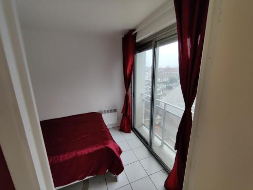 um quarto com uma janela com um sofá vermelho ao lado de uma janela em Appartement à côté de Disneyland Paris CK-triomphe em Esbly