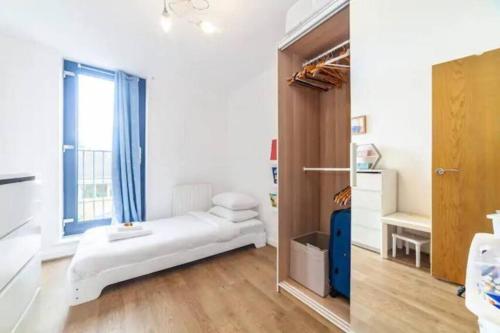 um quarto com uma cama e uma grande janela em Charming 2 Bed flat near Greenwich em Londres