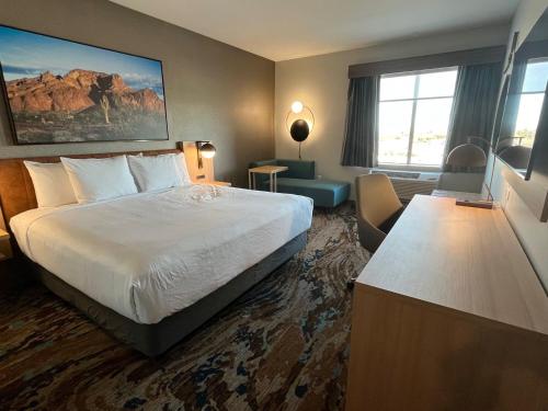 ユマにあるLa Quinta Inn & Suites by Wyndham Yumaの大きなベッドと大きな窓が備わるホテルルームです。