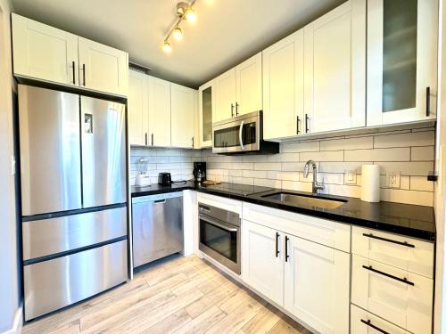 a kitchen with white cabinets and stainless steel appliances at HOT TUB HOUSE ON GOLF COURSE! 10 MINs TO THE BEACH in Miami