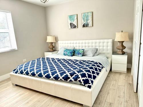 a bedroom with a bed with a blue and white comforter at HOT TUB HOUSE ON GOLF COURSE! 10 MINs TO THE BEACH in Miami