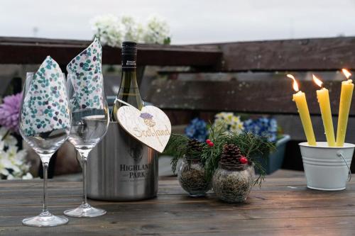 Dunedin House -Contractors - Business Travellers في هونتلي: زجاجة من النبيذ وكأسين على طاولة خشبية