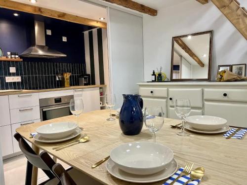 une table de salle à manger avec des assiettes et des verres dessus dans l'établissement Le Chaptal • Beau T2 • CLIM • Centre Gare St Roch, à Montpellier