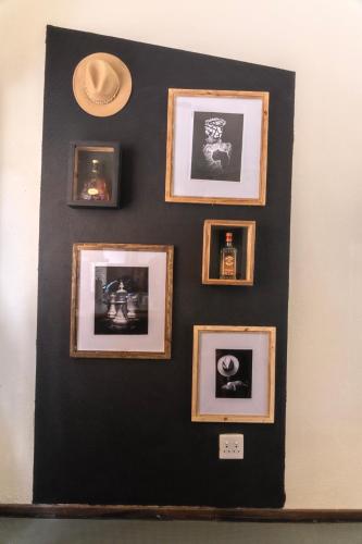 a black wall with framed pictures on it at Arched Farmstead in Eerstegoud