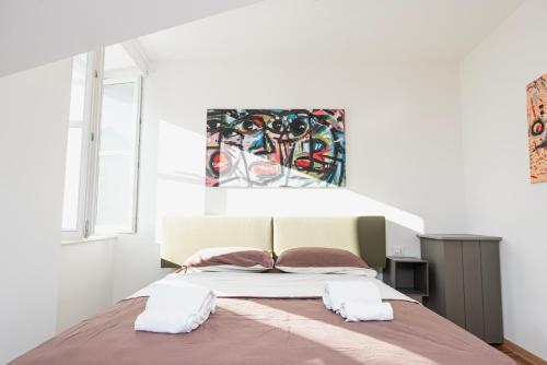 1 dormitorio con 1 cama con 2 toallas en Le Finestre Boutique Apartments en Trieste