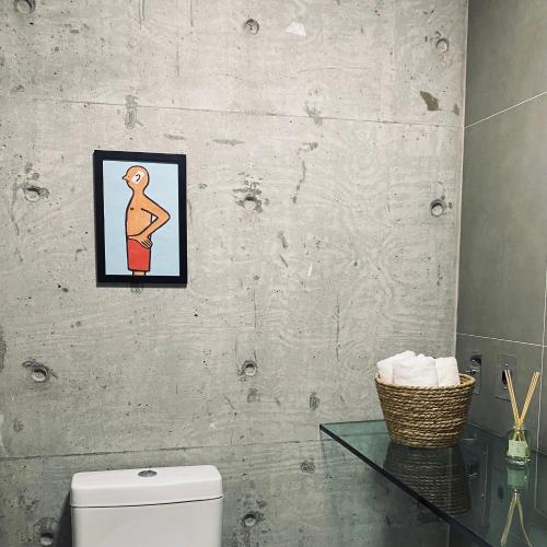 a bathroom with a toilet and a picture on the wall at The Green Hill com piscinas em Praia Brava in Itajaí