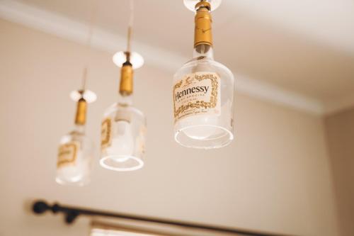 three bottles of wine hanging from a ceiling at Industrial farm stay in Polokwane in Eerstegoud