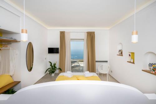 a white room with a bed and a window at L'Acquolella in Positano