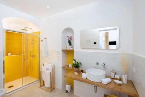 La salle de bains est pourvue d'une douche jaune et d'un lavabo. dans l'établissement L'Acquolella, à Positano
