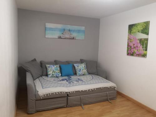 un divano in una stanza con due foto sul muro di Casa DE LAS HADAS a Arinaga