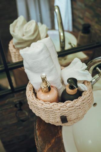 a basket of towels and toiletries on a bathroom sink at Arched Farmstead in Eerstegoud