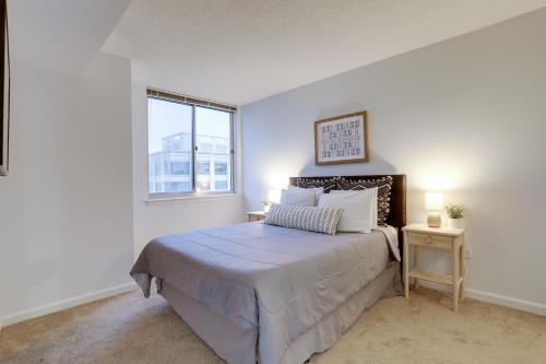 a white bedroom with a bed and a window at Apartment with Panoramic City view of Ballston in Arlington