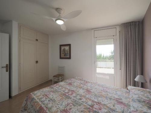 1 dormitorio con cama y ventana en InmoSantos Oasis A1, en Roses