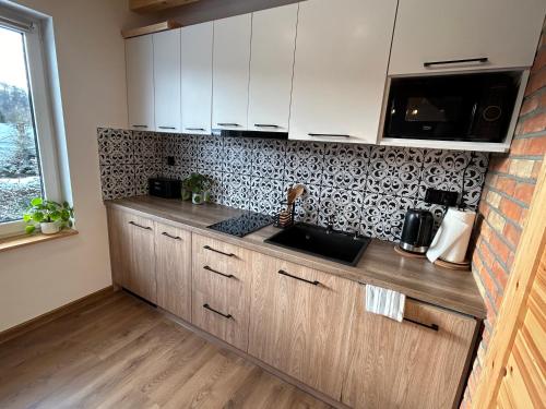 a kitchen with a sink and a counter top at Cichata - domek w Bieszczadach in Czarna
