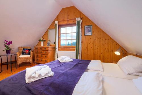 a bedroom with a blue bed with towels on it at Hüttenchalet Waldschatz in Alpirsbach