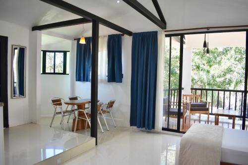a living room with a table and blue curtains at Fuego Lodge in Santa Teresa Beach