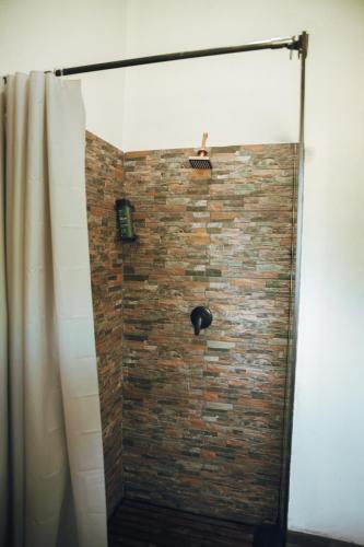 a bathroom with a shower with a brick wall at Arched Farmstead in Eerstegoud