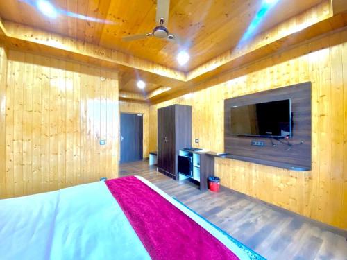 a bedroom with a large bed and a tv at The Walnut Homestay I Kasauli I Perfect Stay in Kasauli