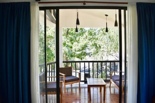 a room with a balcony with a table and chairs at Fuego Lodge in Santa Teresa Beach