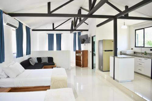 a living room with a bed and a kitchen at Fuego Lodge in Santa Teresa Beach