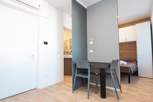 a room with a table and chairs and a bedroom at Hurban Apartments Venezian in Trieste