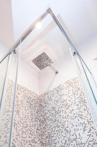 a shower with a glass door in a bathroom at Hurban Apartments Venezian in Trieste