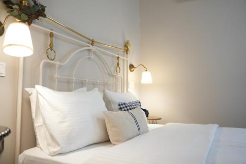 a bedroom with a white bed with white pillows at Guesthouse Doma est 1991 in Arachova