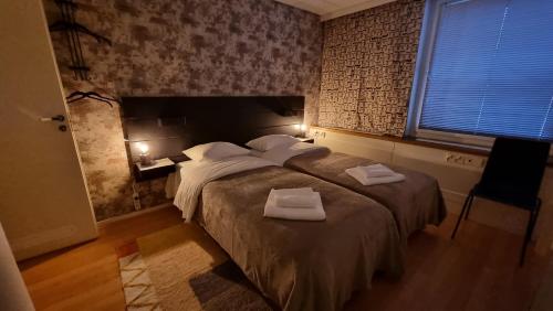 a bedroom with a large bed with two towels on it at Aparthotel Clock 2 in Kotka
