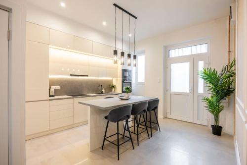 a kitchen with white cabinets and a island with bar stools at Luxury & Classy Central Apartment with 3BEDRM, 2BATHRM in Budapest