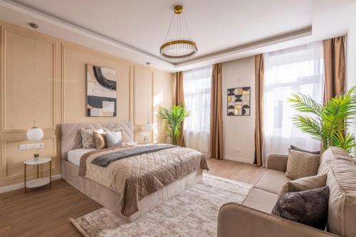 Luxury & Classy Central Apartment with 3BEDRM, 2BATHRM في بودابست: غرفة نوم بسرير كبير وأريكة
