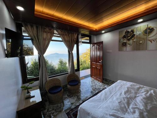 a bedroom with a bed and a large window at Morning Mist Homestay in Gangtok