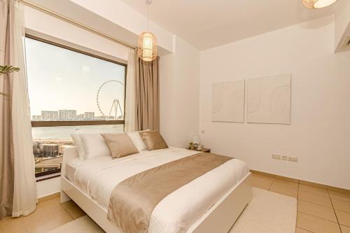a bedroom with a large bed and a large window at GMA Rimal5 4BR Sea View in Dubai