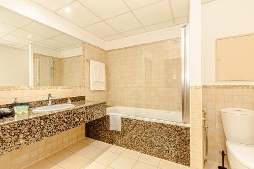 a bathroom with a toilet and a sink and a tub at GMA Rimal5 4BR Sea View in Dubai