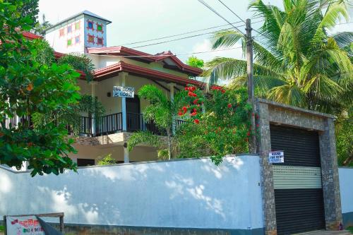 a house with a gate in front of it at Bandara House in Midigama