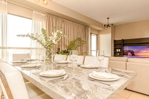 a dining room with a table with wine glasses at GMA Rimal5 4BR Sea View in Dubai