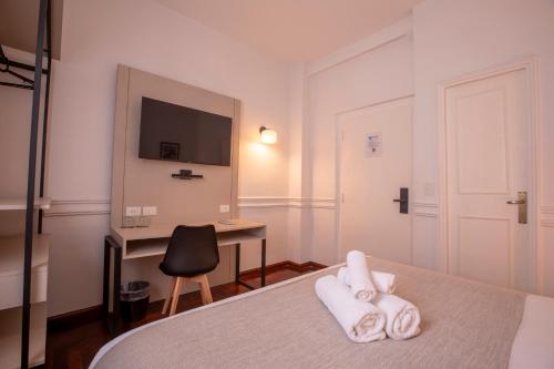 un dormitorio con una cama con toallitas. en El Misti Hotel Buenos Aires Centro en Buenos Aires