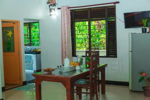 a kitchen with a small table and a refrigerator at Bandara House in Midigama